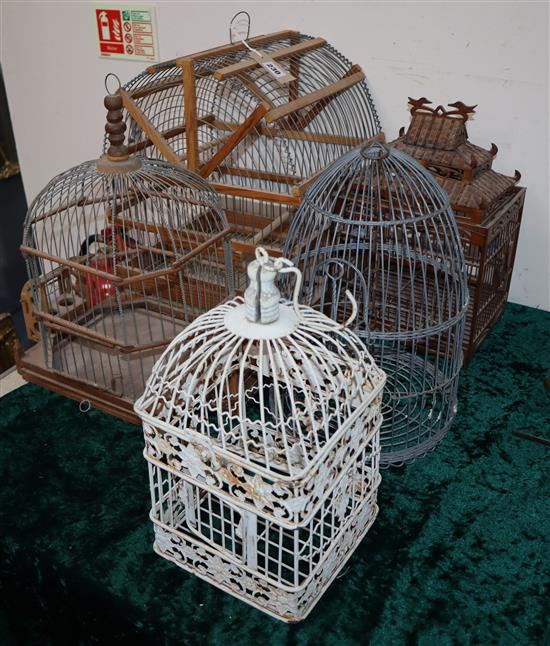 A Chinese wired birdcage with blue and white water feeders and four other wood and wirework birdcages